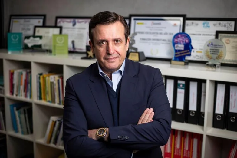 Ignacio Campoy: las empresas felices son empresas rentables Ignacio Campoy con los brazos cruzados junto a una estantería con premios de Formación Universitaria